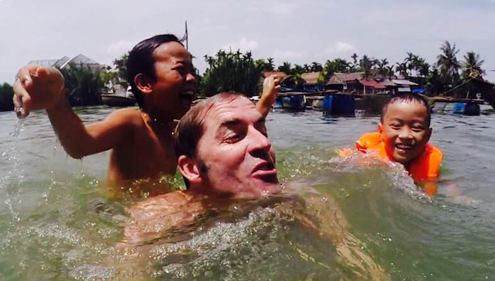Picture of Roy Moranz swimming with kids in Vietnam.